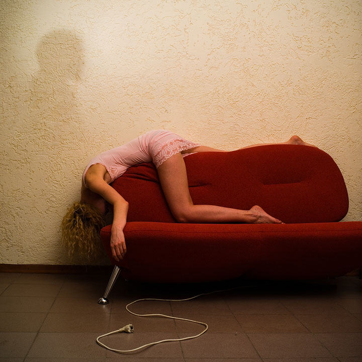 Тридцатитрехлетняя пошлячка позирует на диване в красном лифоне